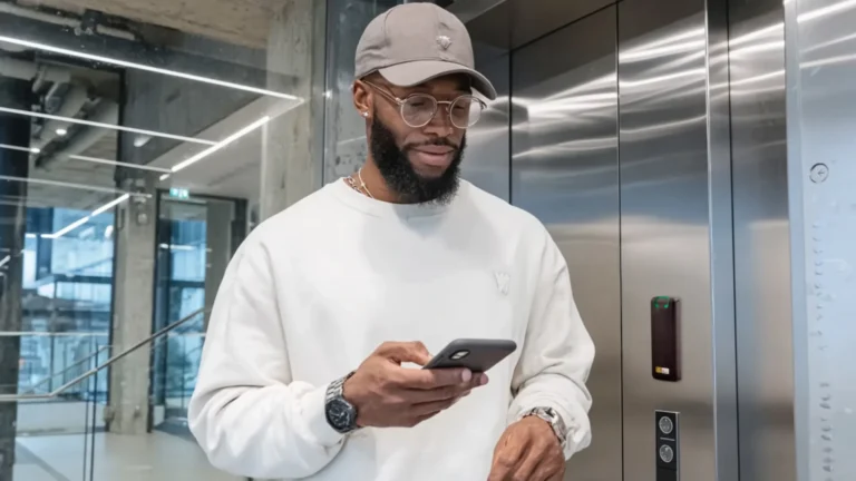 Man using a smartphone with IPROTECT access control system near an elevator