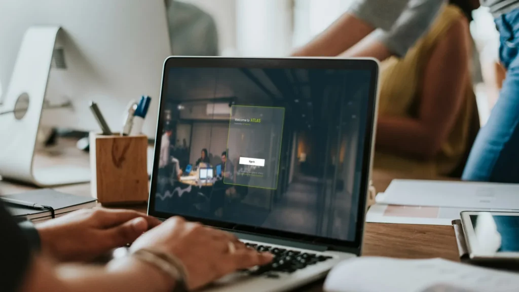 Person using a laptop with ATLAS access control system interface in an office environment