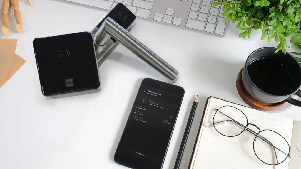 ATLAS access control accessories including smart lock cylinder, mobile device, and workspace setup