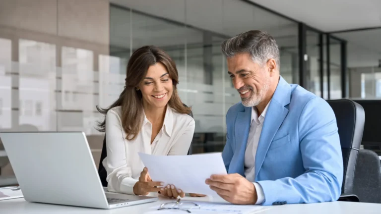 Property managers using ATLAS reviewing data together on a laptop in an office