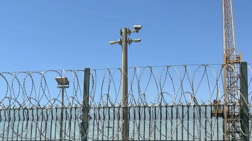 Surveillance cameras above a barbed wire fence achieving optimal surveillance in complex environments