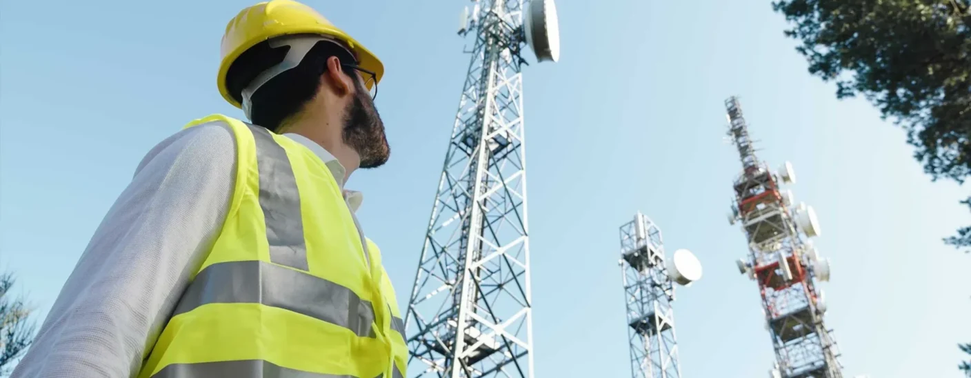 Technician in safety gear inspecting telecommunications towers at VodafoneZiggo site