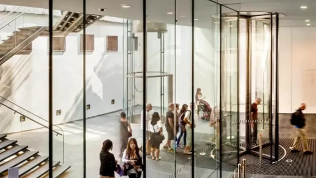 Visitors entering Boon Edam building through a glass entrance with IPROTECT access control systems
