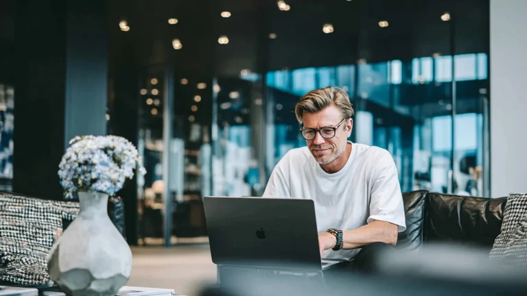 Man using ATLAS software on laptop while sitting in a modern office lounge area
