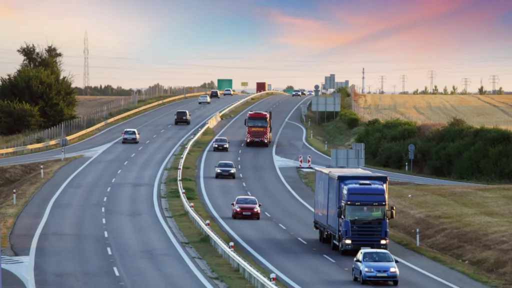 Highway with cars and trucks driving through a transport and infrastructure network