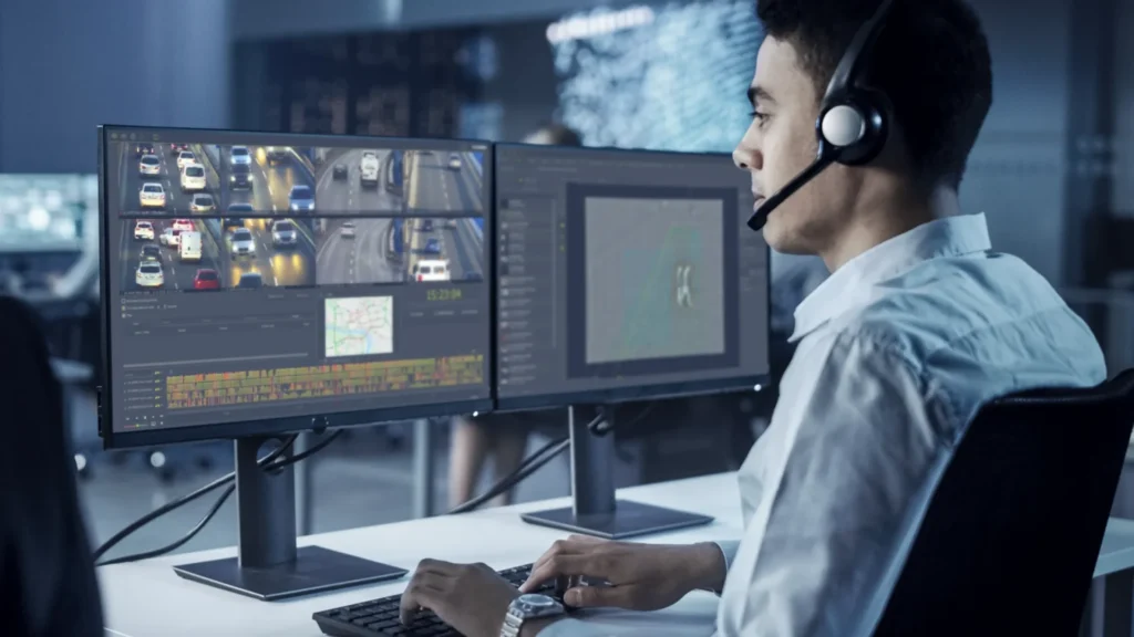 Operator using multiple monitors displaying VDG SENSE video management system interface