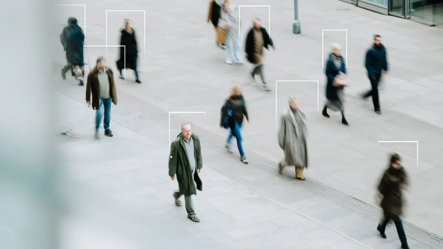 People walking in a public space with individuals highlighted for identification with server based video content analytics